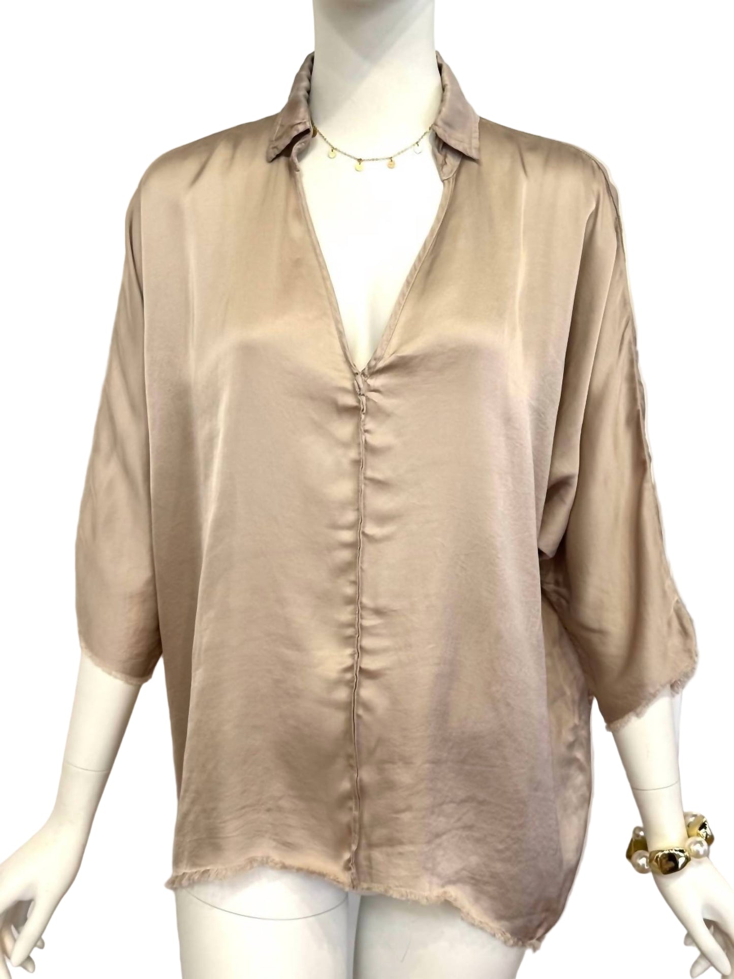 Beige blouse on a mannequin against a white background