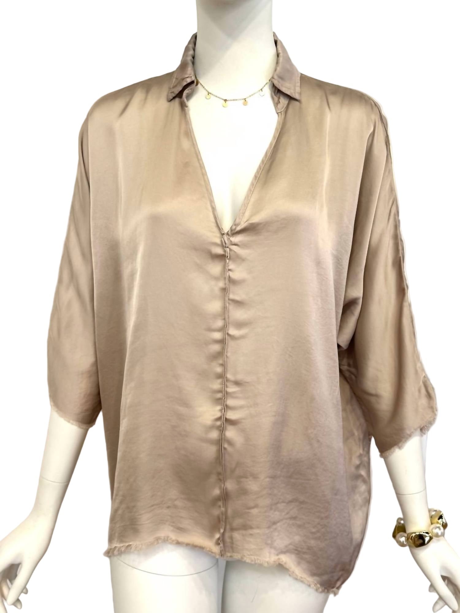 Beige blouse on a mannequin against a white background